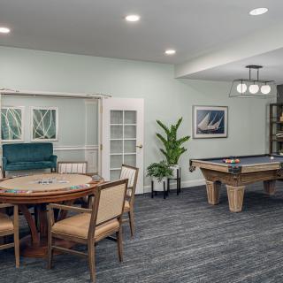 A cozy indoor game room featuring a pool table and board games setup.