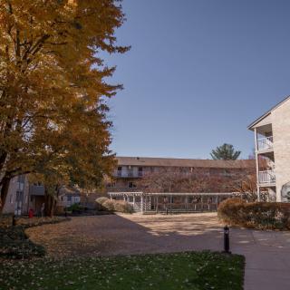 A peaceful residential complex during autumn with colorful trees and clear skies.