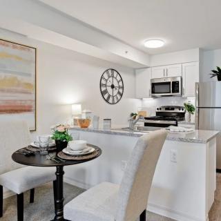 A modern kitchen and dining area with white cabinets and contemporary decor.