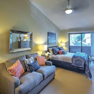 A cozy bedroom with a comfortable sofa and a neatly made bed, complemented by stylish decor and warm lighting.
