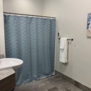 A modern bathroom with a blue shower curtain and neatly hung towel.