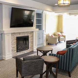 A modern living room featuring a fireplace, large television, and comfortable seating.
