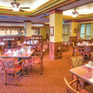 A spacious and well-lit restaurant dining area with neatly arranged tables and chairs.