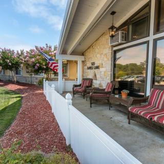 A cozy porch with striped chairs and a well-maintained garden.
