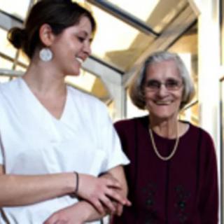 A caregiver assists an elderly woman, providing support and companionship.