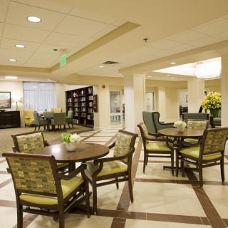 A well-lit lobby with comfortable seating and tables.