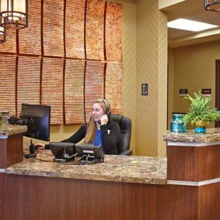 A receptionist working at a modern office reception desk.
