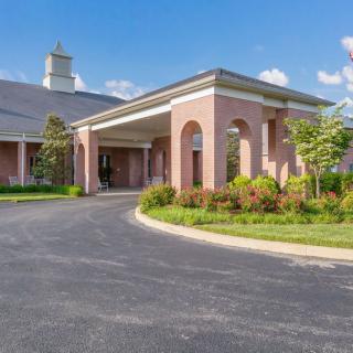 A modern church building with a spacious entrance and landscaped surroundings.