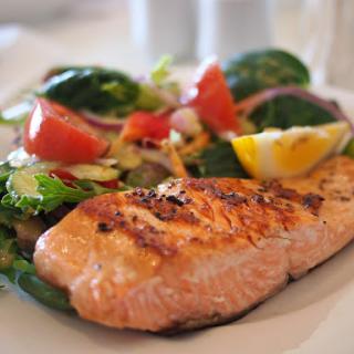 A delicious plate of grilled salmon served with a fresh garden salad.