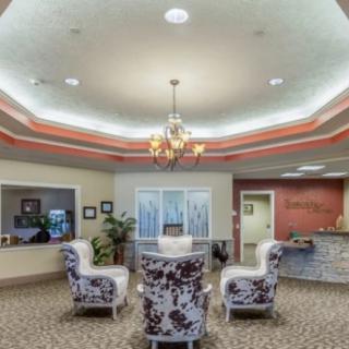 A well-decorated lobby with elegant chairs and a central chandelier.