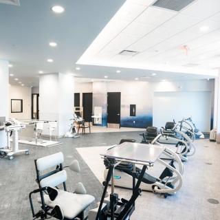 A spacious gym featuring modern exercise equipment and bright interior lighting.