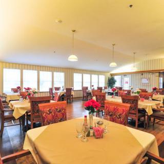 A well-lit dining area with neatly arranged tables and chairs.