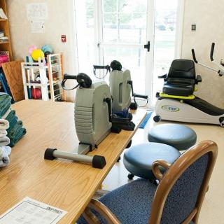 A physical therapy room equipped with exercise machines and seating for rehabilitation.