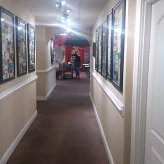 A well-lit hallway adorned with framed artwork on the walls.