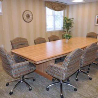 A conference room with a large meeting table and several office chairs.