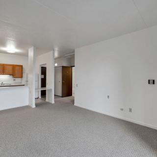 Spacious open-plan living area with a view of the kitchen and hallway.