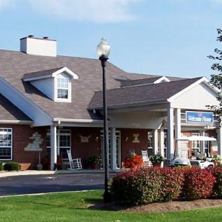 A brick building with a well-maintained front yard and a lamppost.