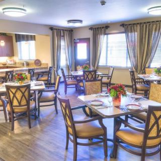 A cozy dining room with elegantly set tables and soft lighting.