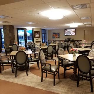 A spacious dining area featuring neatly arranged tables and chairs, designed for gatherings and meals.