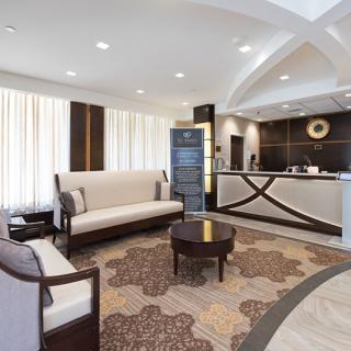 A modern hotel lobby with comfortable seating and a reception desk.