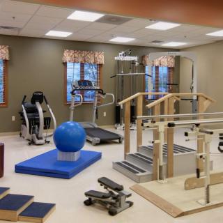 A physical therapy room equipped with various rehabilitation and exercise equipment.