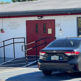 A view of a building entrance with a wheelchair ramp and a parked car.