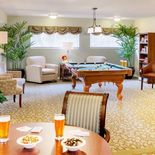 A cozy lounge with a pool table, comfortable seating, and elegant decor.