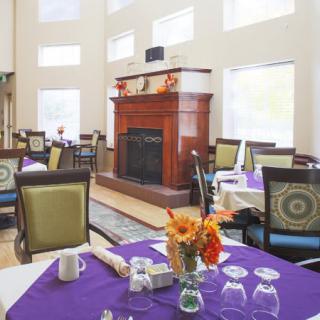 A cozy dining area with elegantly set tables and a fireplace.