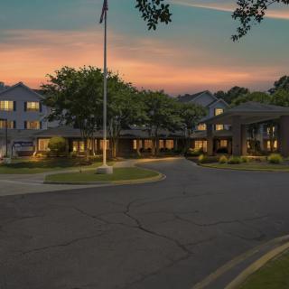 A picturesque view of a building surrounded by trees at sunset.