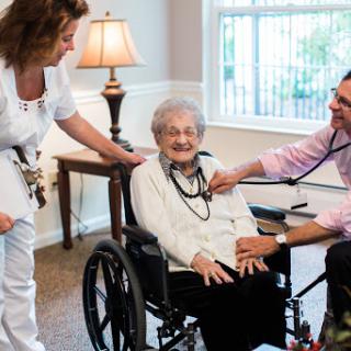 A healthcare professional checks on an elderly patient in a nursing home setting, showcasing compassion and care.