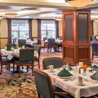 A spacious dining area with elegantly set tables and comfortable seating.
