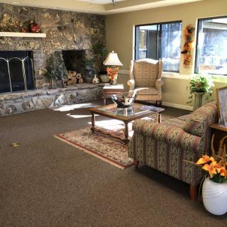 A cozy living room with a stone fireplace and comfortable seating.