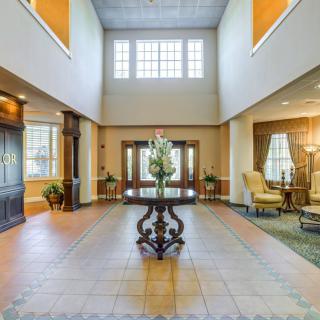 A spacious and elegantly designed lobby with a central decorative table and comfortable seating areas.
