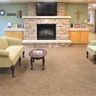 A cozy living room featuring a stone fireplace, comfortable seating, and a television, creating a warm and inviting atmosphere.