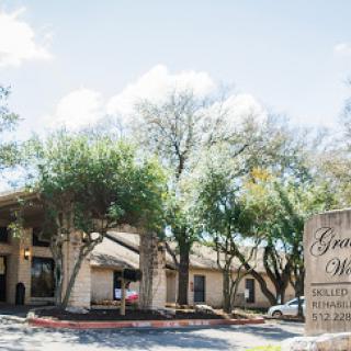 A picturesque view of the hotel entrance surrounded by lush trees.