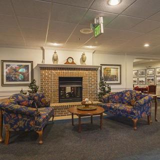 A cozy living room interior featuring a fireplace, sofas, and decorative artwork.