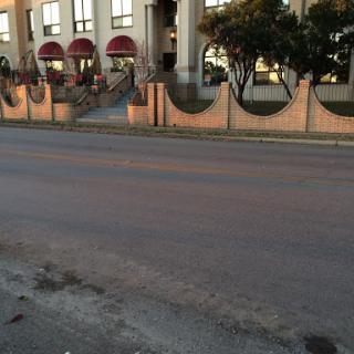 A view of a building with decorative entrances and a quiet street.
