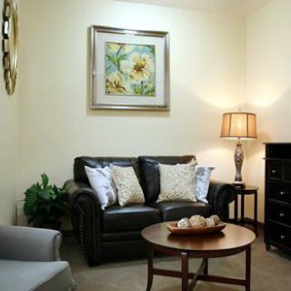 A cozy living room with a leather sofa, coffee table, and elegant lighting.