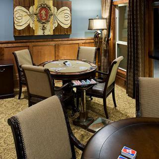 A cozy gaming room featuring a poker table and comfortable seating.