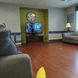 A cozy living room with a TV, comfortable seating, and warm lighting.