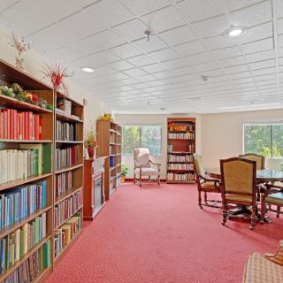 A cozy library room with bookshelves and a reading area.