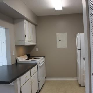 A compact kitchen with white appliances and cabinets.