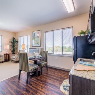 A bright, open-plan kitchen and dining area with hardwood floors and large windows.