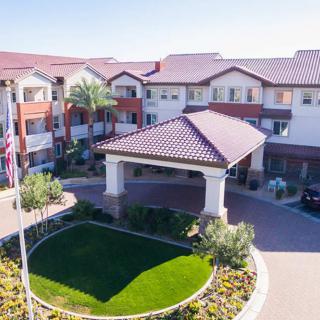 Aerial view of a large residential building with landscaped gardens and a main entrance.