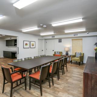 A spacious conference room with a long table, multiple chairs, and modern decor.