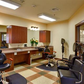 A well-lit salon interior featuring barber chairs and mirrors.