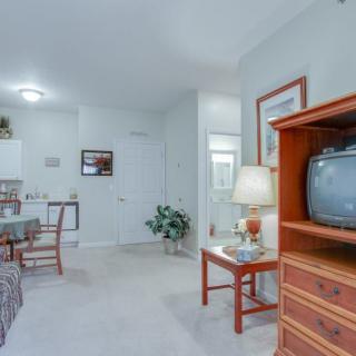 A cozy living room with a television, seating area, and various furnishings.