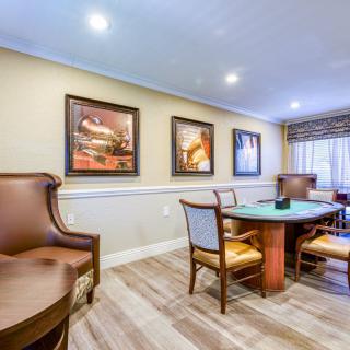 A cozy dining room with a round table, comfortable chairs, and artwork on the walls.