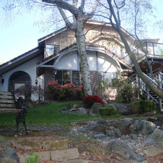 A beautifully designed home surrounded by lush greenery and elegant landscaping.