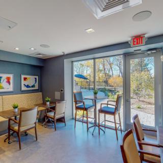 A cozy cafe interior with seating and large windows allowing natural light.